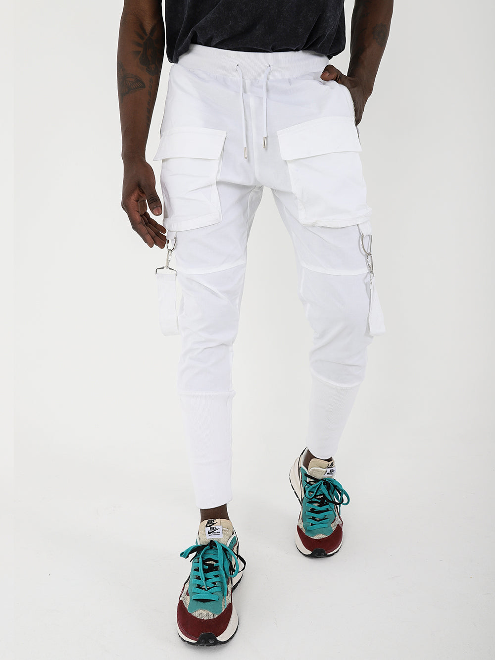 A slim fit jogger wearing white cargo pants and adjustable drawstring waist BROOKLYN JOGGERS sneakers.