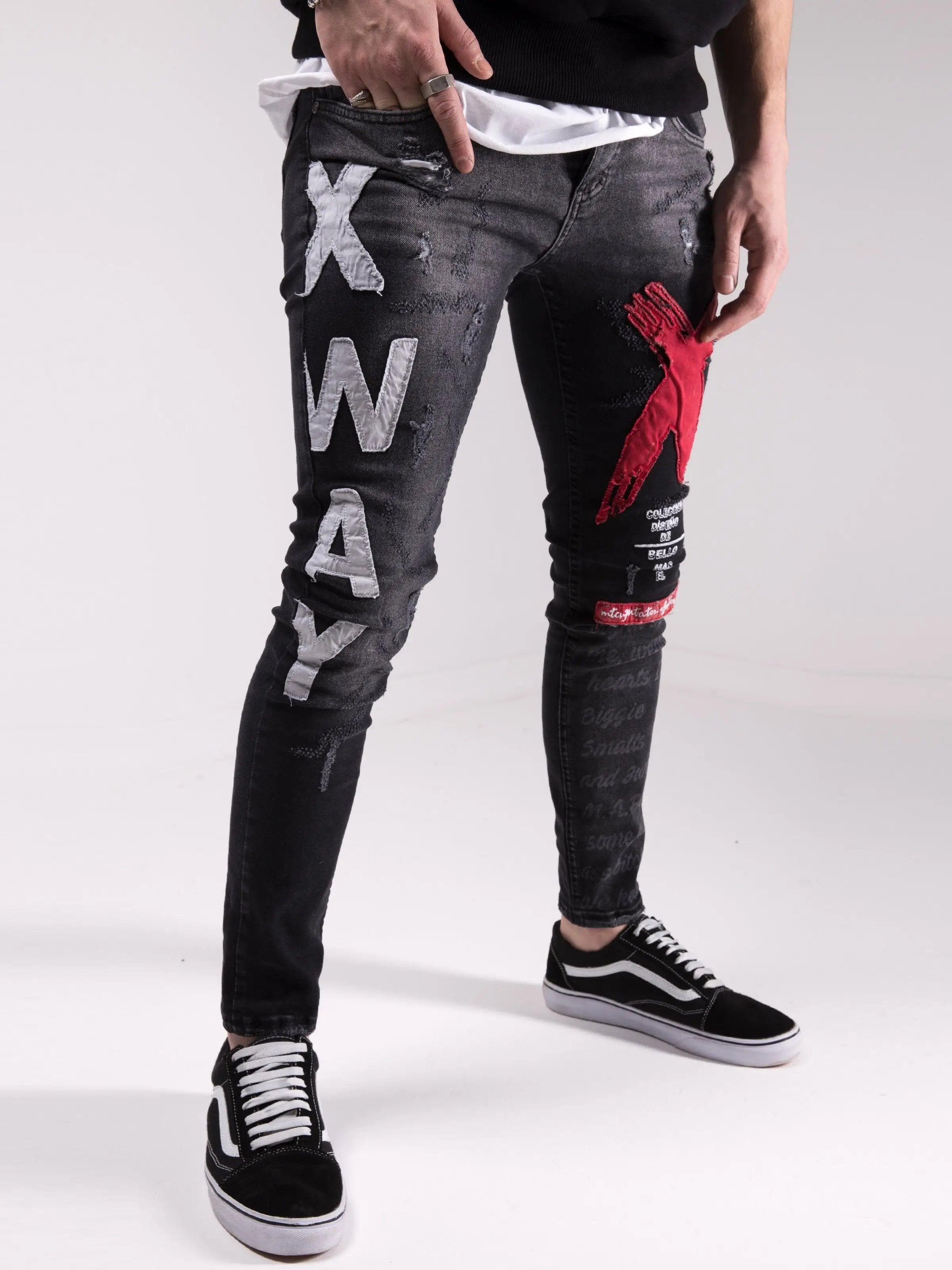 A man wearing a pair of MAD DOG skinny fit black jeans with red and white stripes, a staple in mens streetwear.