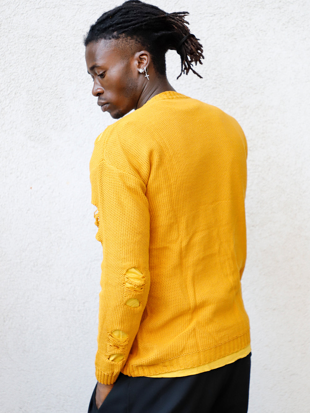 A man wearing a yellow DISTRESSED DOUBLE LAYER SWEATER // MUSTARD with a true to size fit.