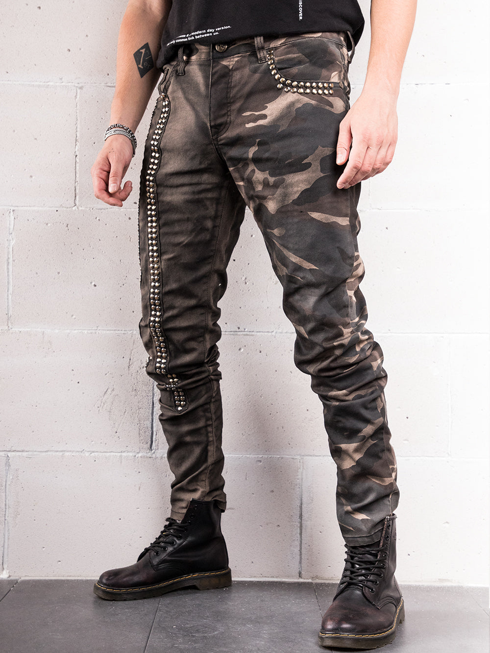 A man wearing SNIPER hand-crafted black camouflage pants with a skinny fit.