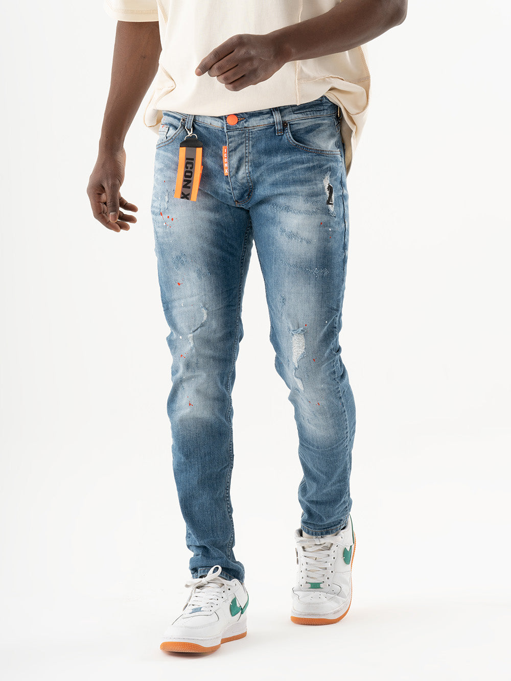 A man wearing TEZAR jeans and a white t - shirt.