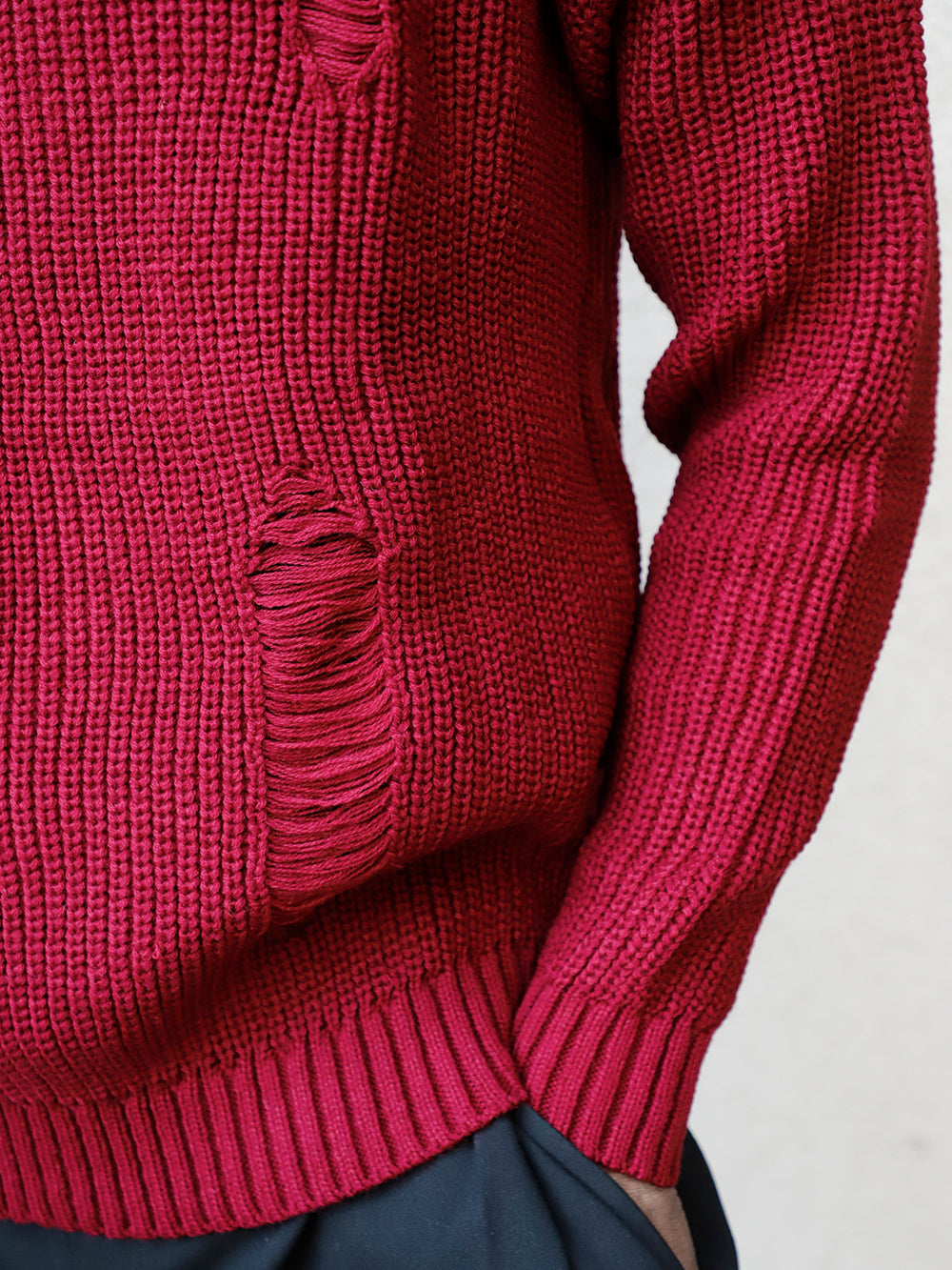 A man wearing a red DISTRESSED GENTLEMAN SWEATER | BURGUNDY made of Acrylic.