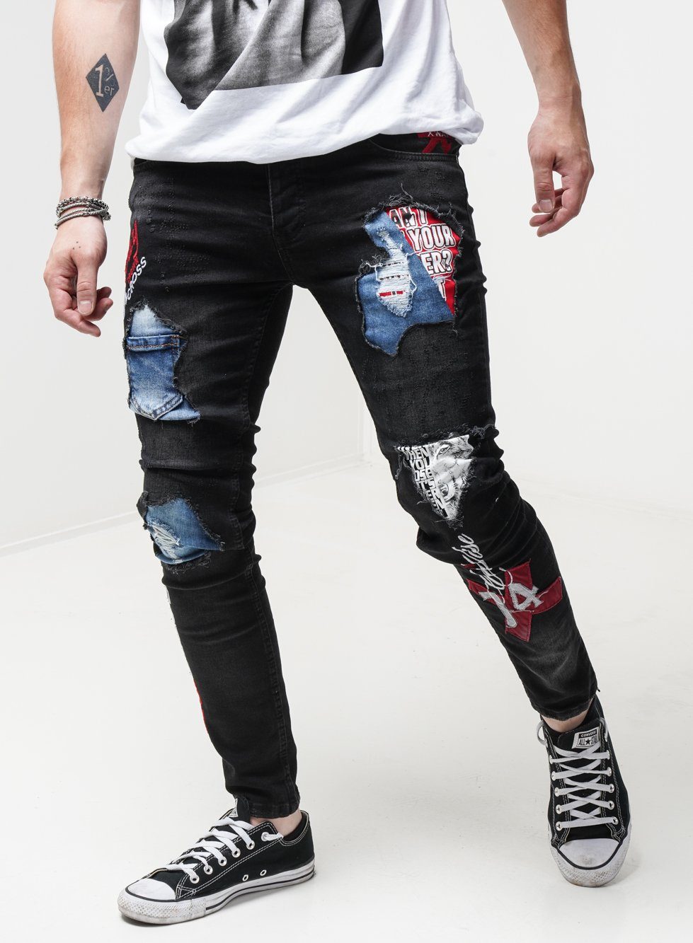 A man rocking INSIDER ripped jeans in a skinny fit, paired with a casual white t-shirt.