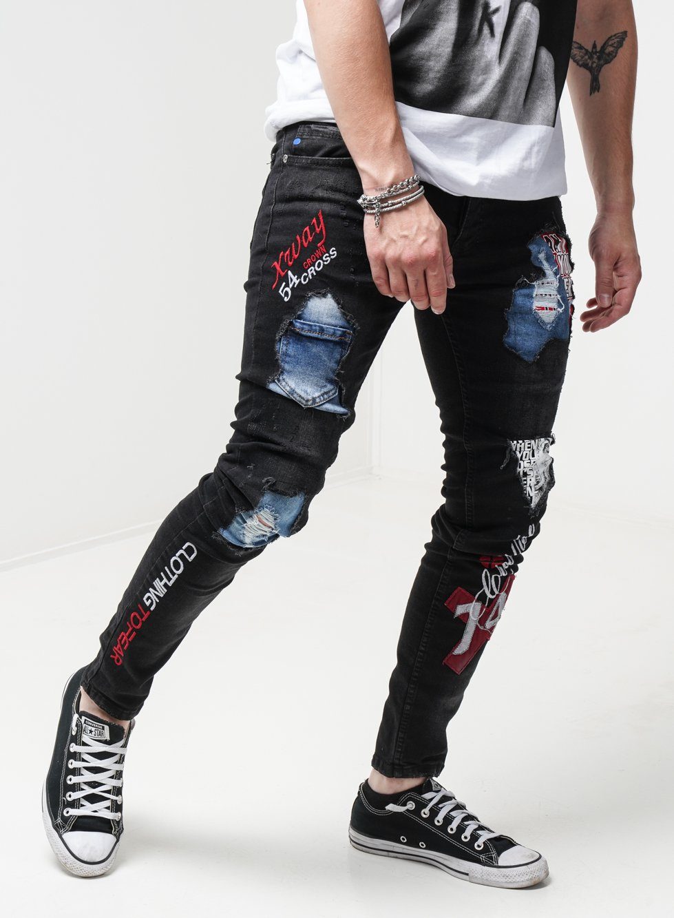 A man donning INSIDER skinny ripped jeans in a t-shirt, showcasing mens streetwear style.