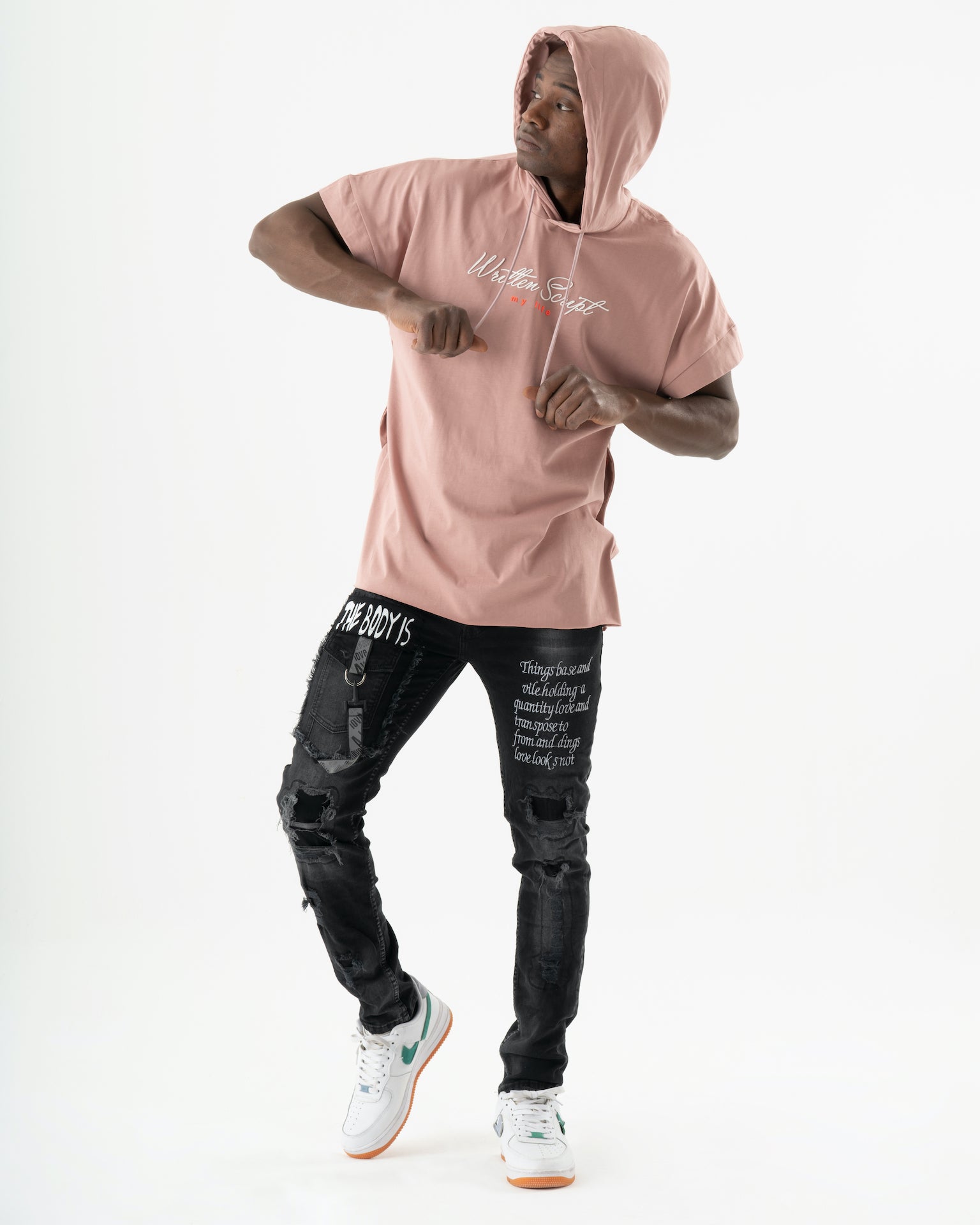 A man wearing a ONE SOUL pink hoodie and black jeans.