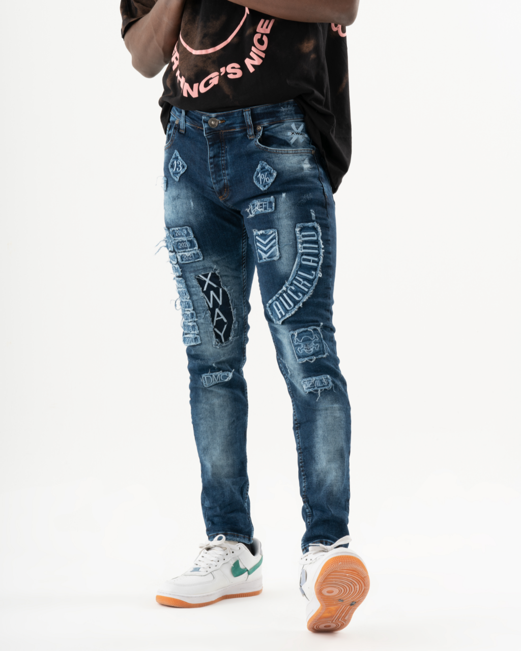 A man in INJUN | BLUE streetwear jeans and a t-shirt.