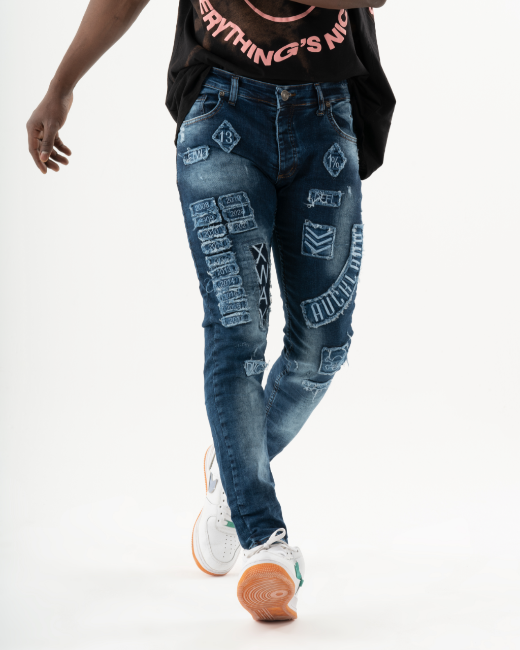 A man donning INJUN | BLUE skinny fit jeans and a t-shirt in mens streetwear style.