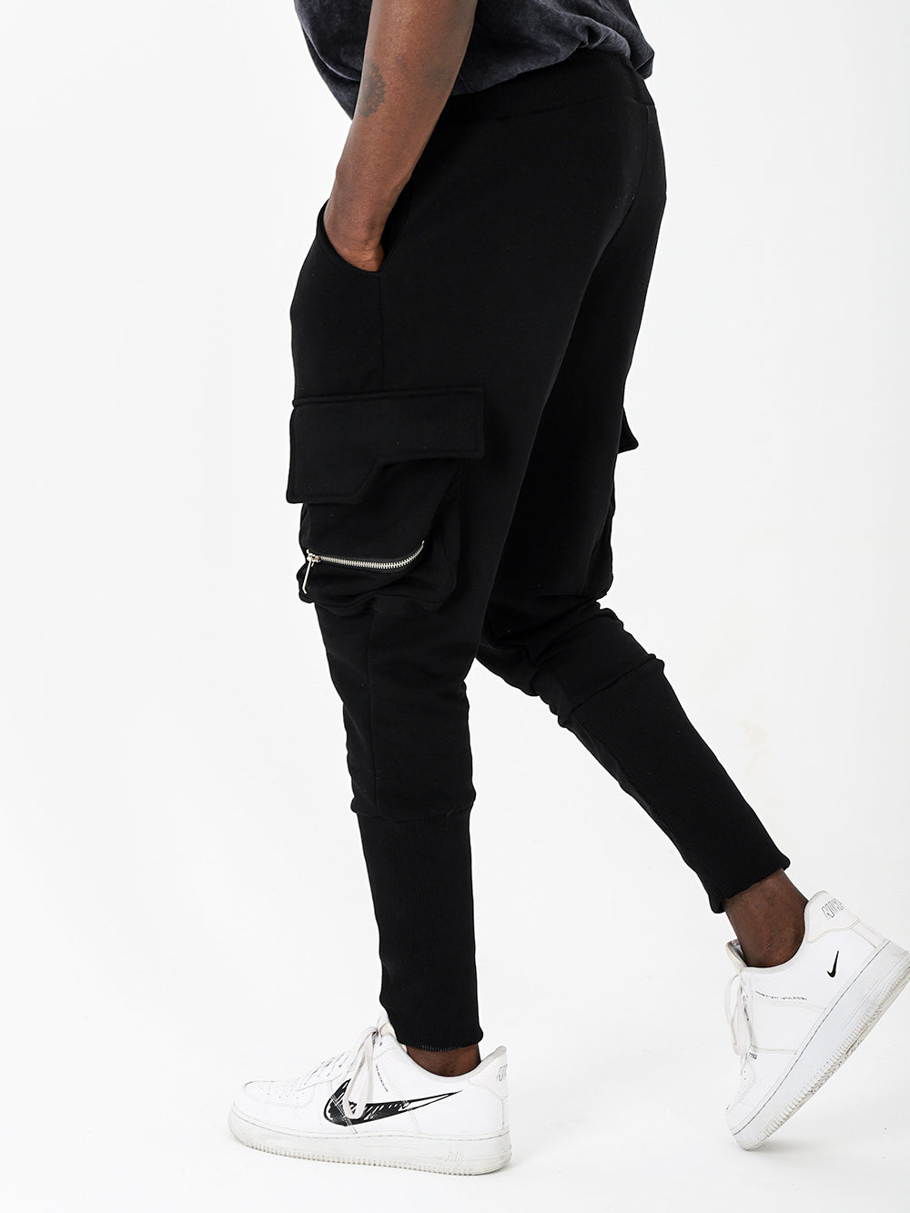 A man wearing black Rambo joggers, perfect for comfort and with plenty of pockets, paired with white sneakers.