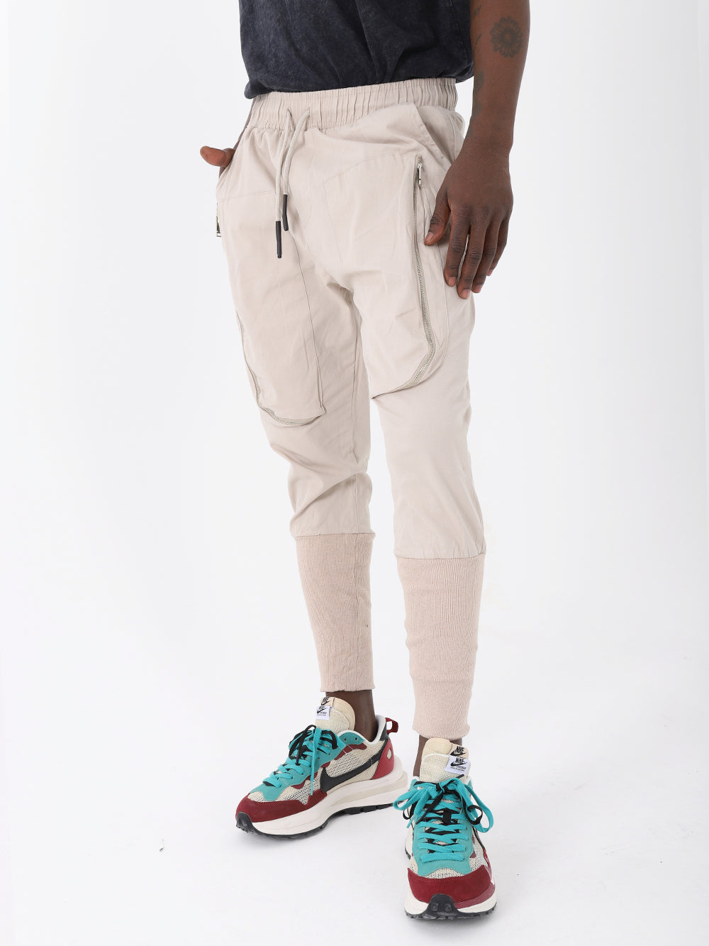A fashionable man wearing ALTIS JOGGERS with an adjustable drawstring waist and sneakers.