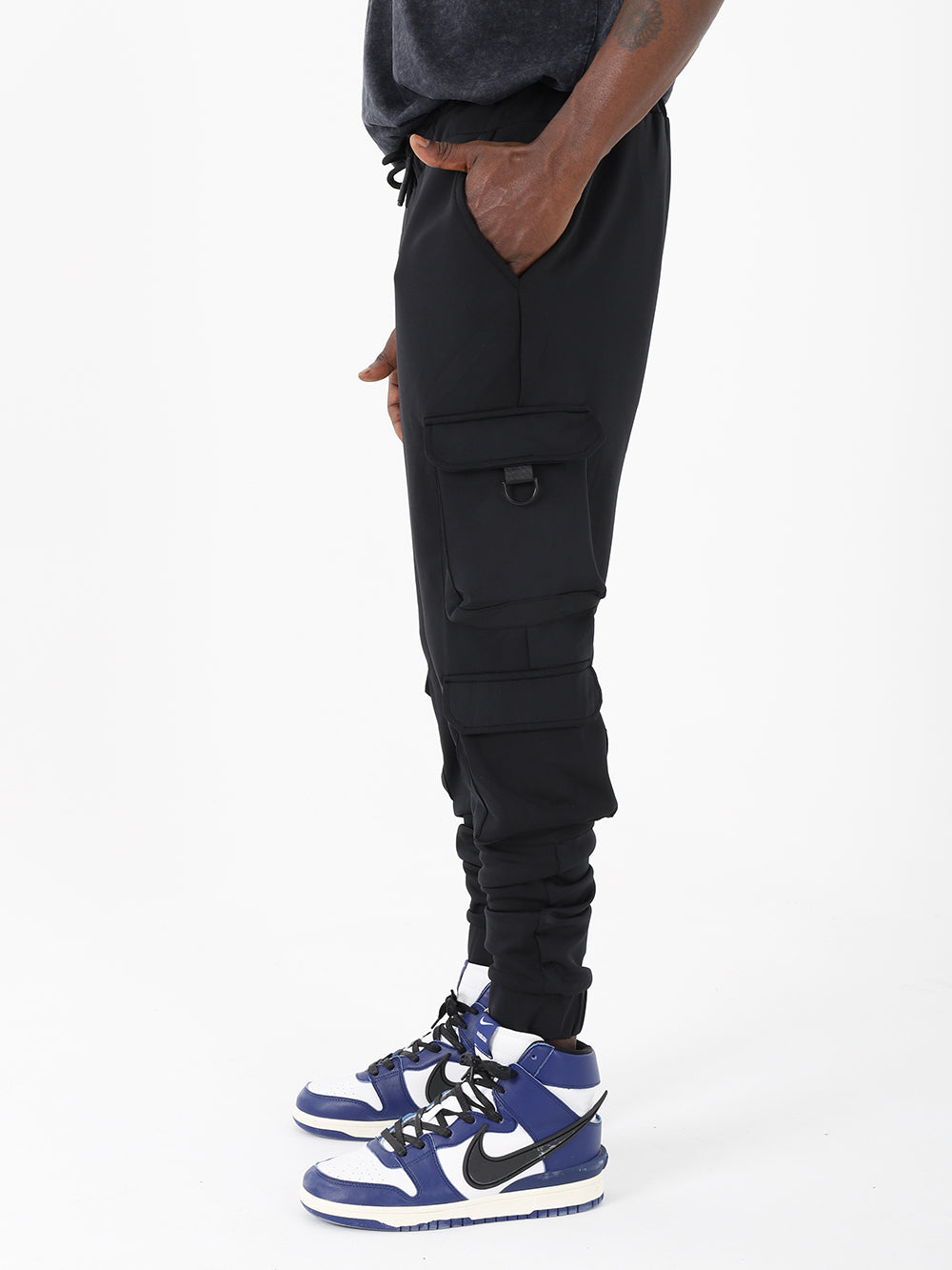 A man wearing VENTURA JOGGERS with adjustable ankle cuffs and a drawstring waist, paired with sneakers.