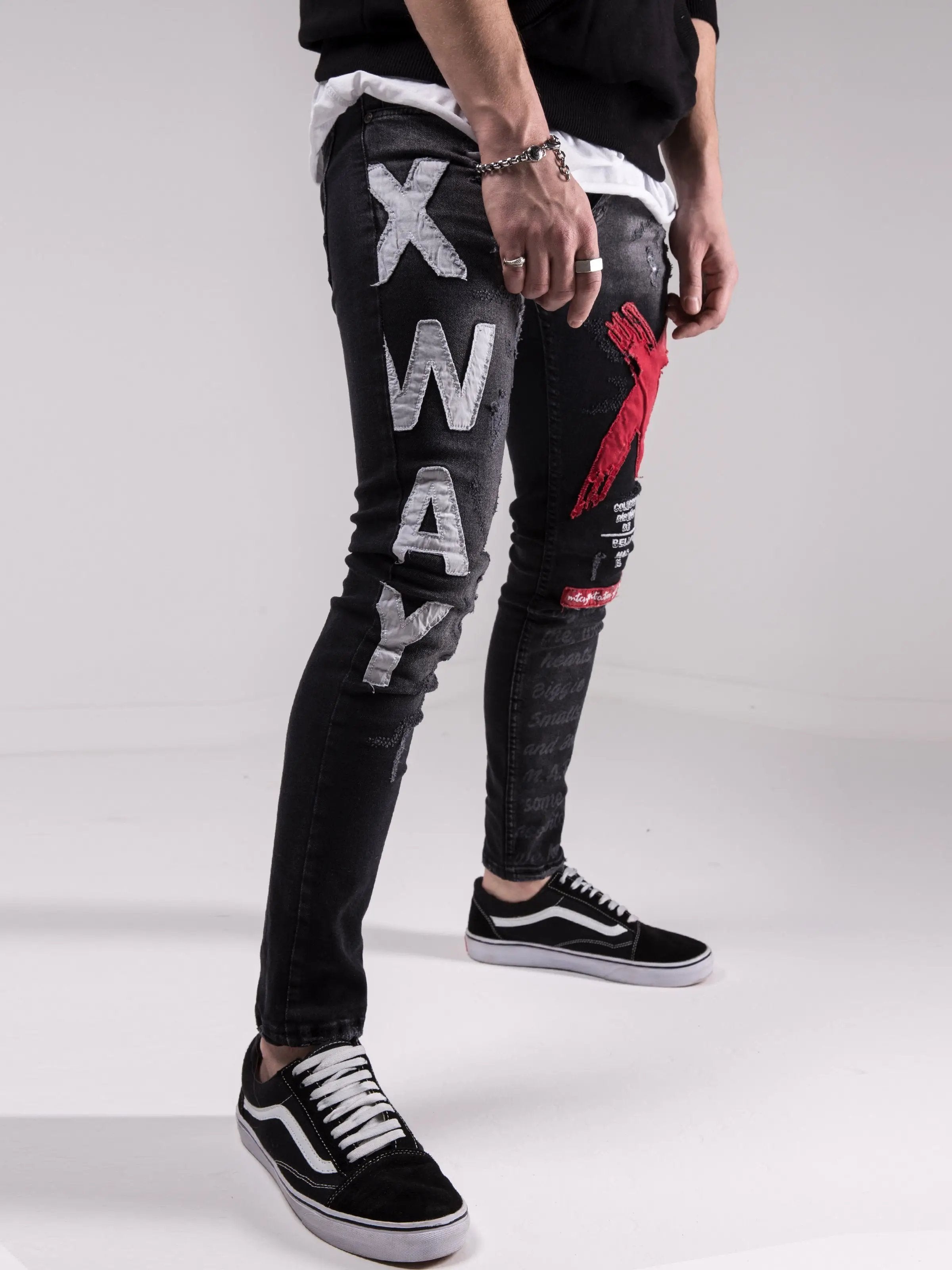A man wearing a pair of skinny fit jeans with the word MAD DOG written on them.