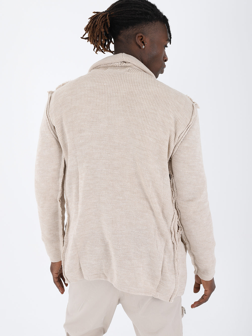 The man wearing an ASYMMETRIC SHORT CARDIGAN // IVORY and khaki pants has a true to size fit.
