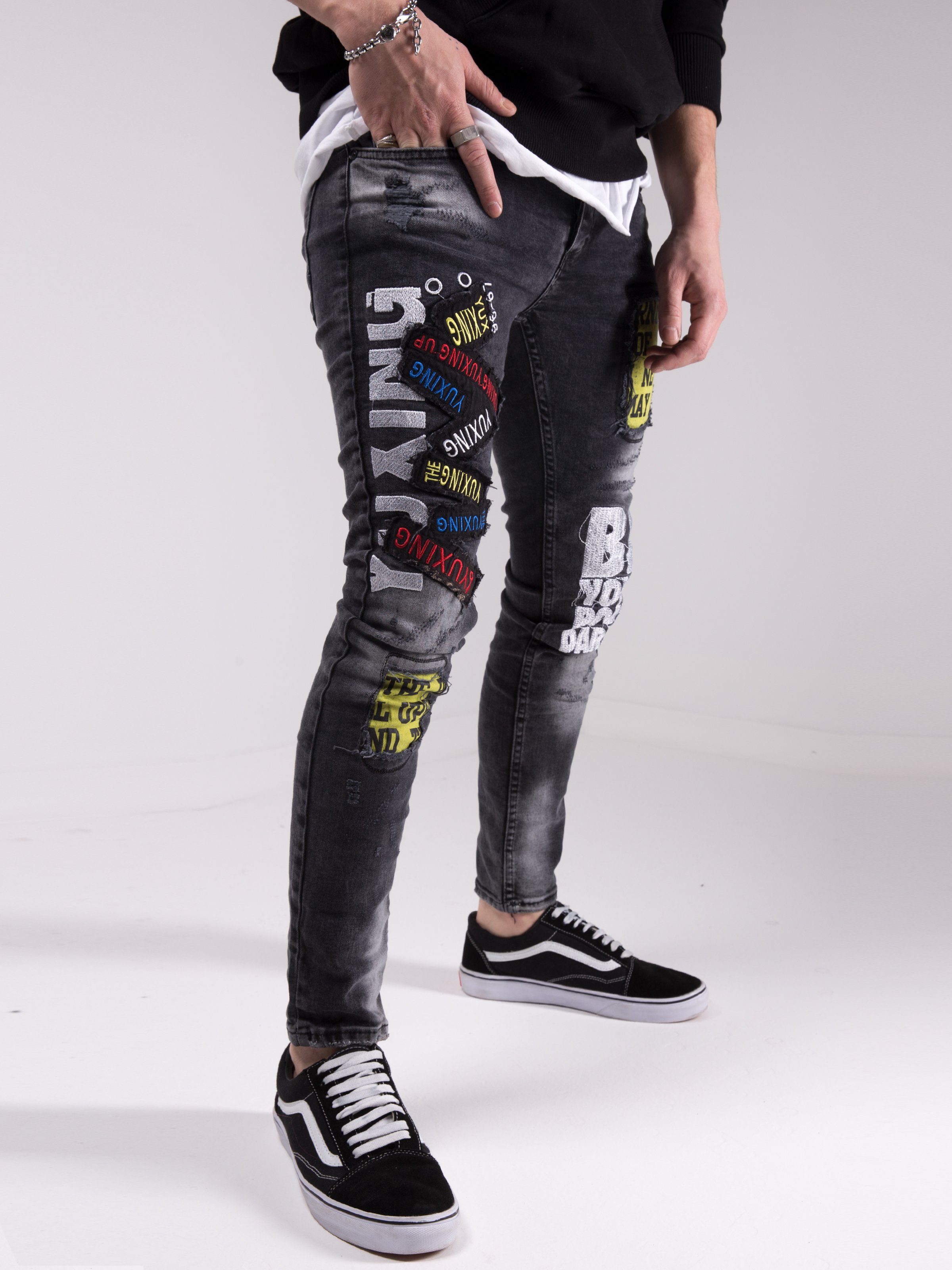 A man wearing a pair of SAVAGE SECRET jeans with graffiti on them.
