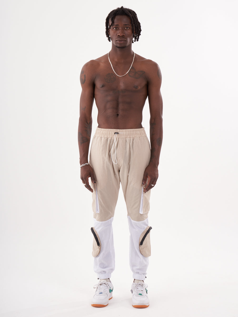 A man in a RENEGADE | BEIGE striped jogger pants.