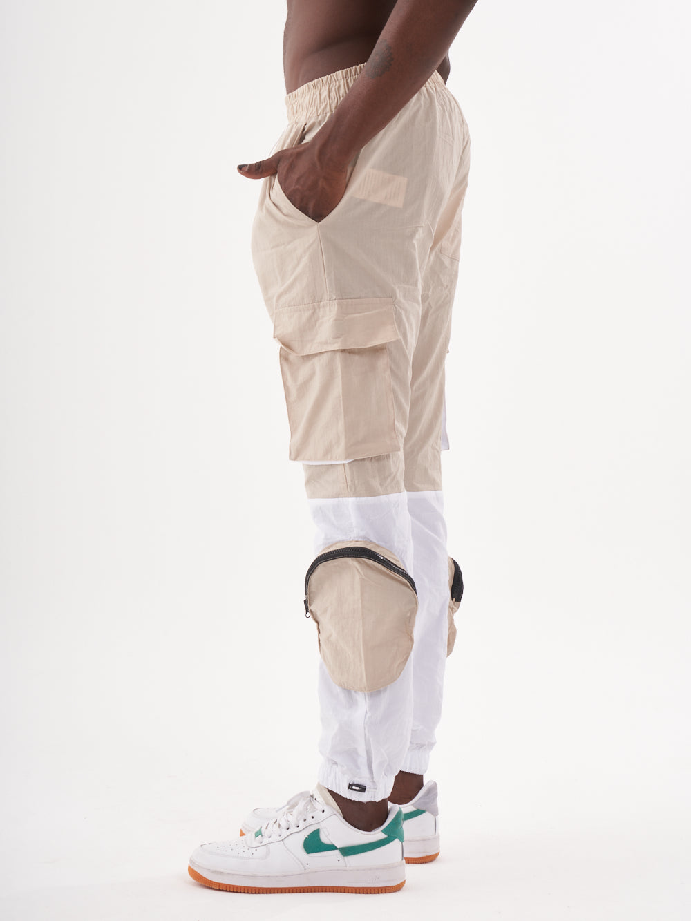 A man wearing the RENEGADE | BEIGE cargo pant and white sneakers.