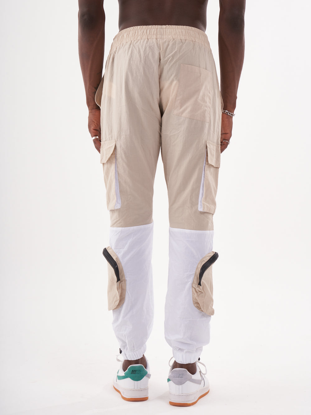 The back view of a man wearing RENEGADE | BEIGE cargo pants in beige and white.