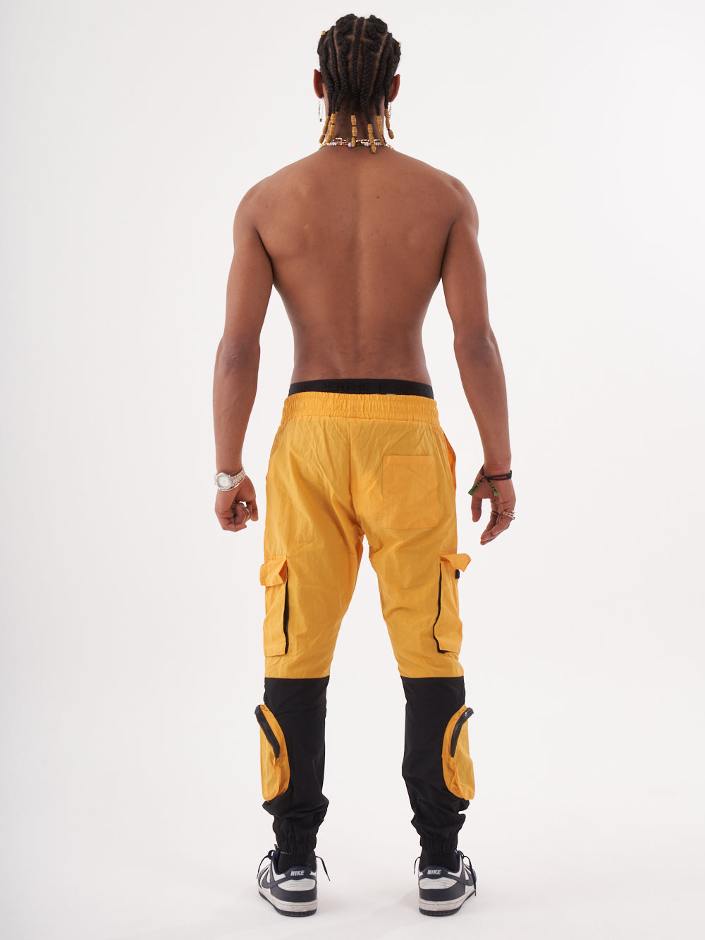 The back view of a man wearing RENEGADE | YELLOW cargo pants.