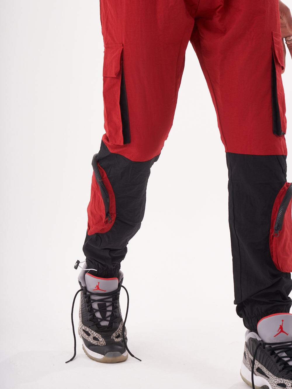 A man wearing a red and black RENEGADE | RED cargo pants.