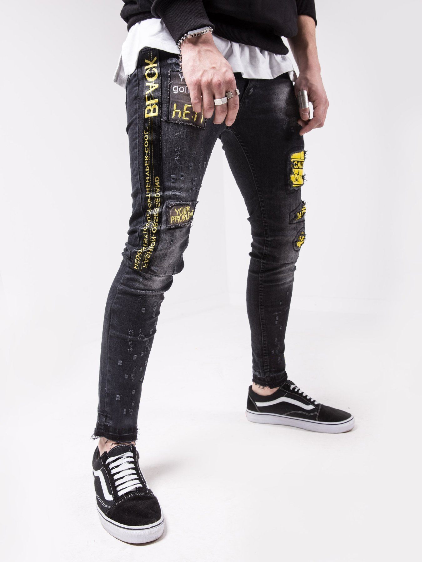 A man wearing BLACK FALCON jeans with yellow stripes.