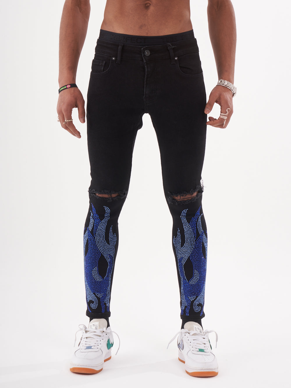 A man wearing HELLFIRE | BLUE jeans with blue flames on them.