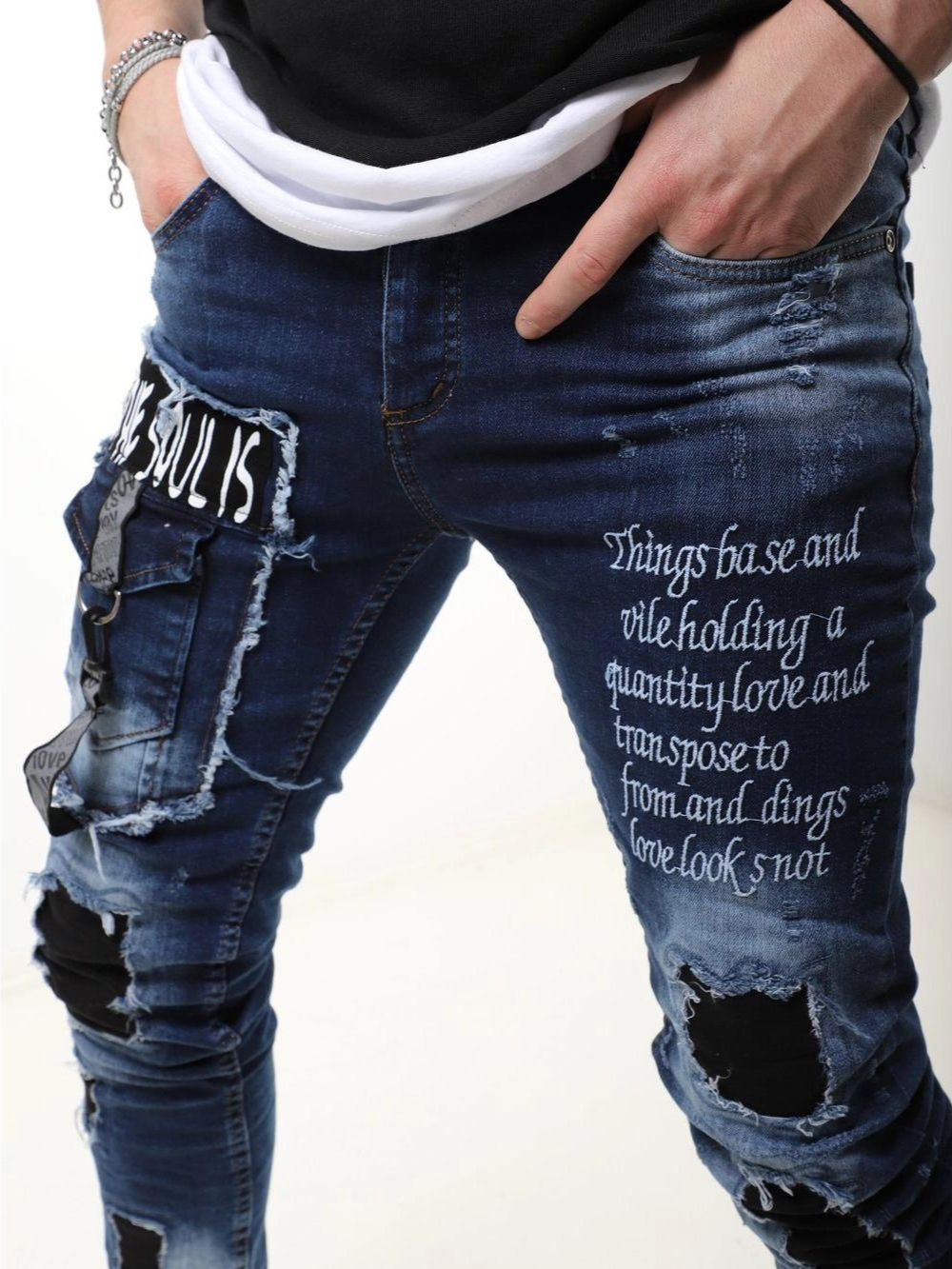 A man wearing BLUE SOUL jeans with a quote on them.