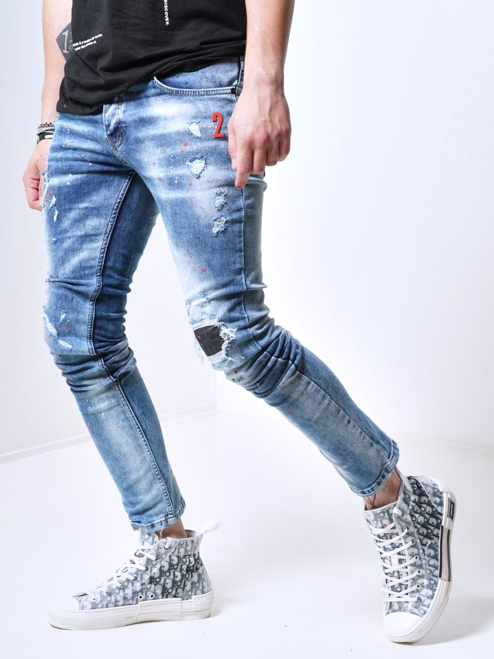 Side shot of a man wearing the skinny fit distressed jeans called THE SPECIAL ONE with rips and patches by SERNES