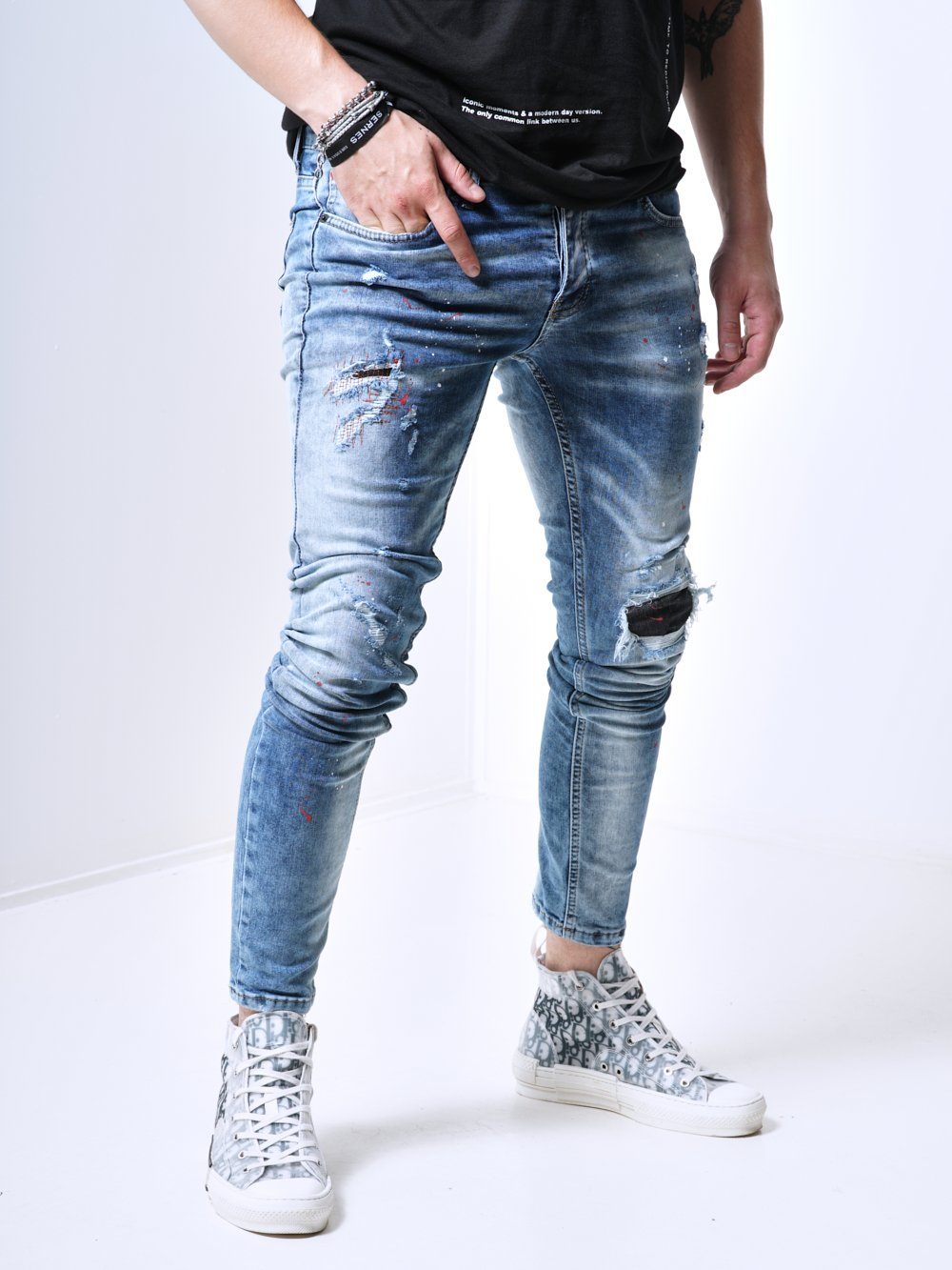 Side shot of a man wearing the skinny fit distressed jeans called THE SPECIAL ONE  with rips and patches by SERNES