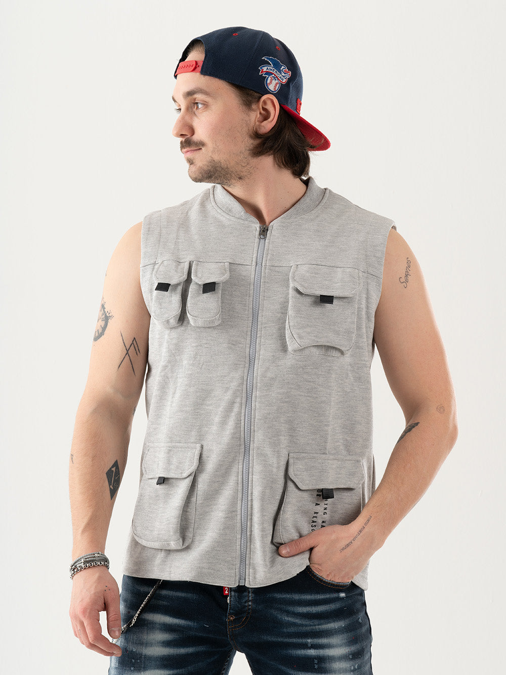 A man wearing a FREESPIRIT VEST with multi-pocket cargo pockets and a hat.