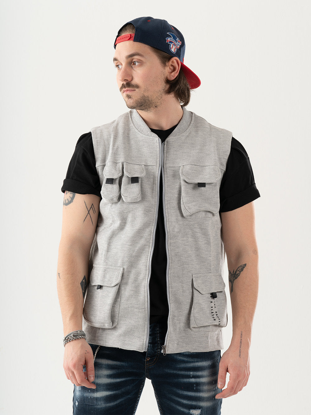 A man wearing a FREESPIRIT VEST with cargo pockets and a hat.