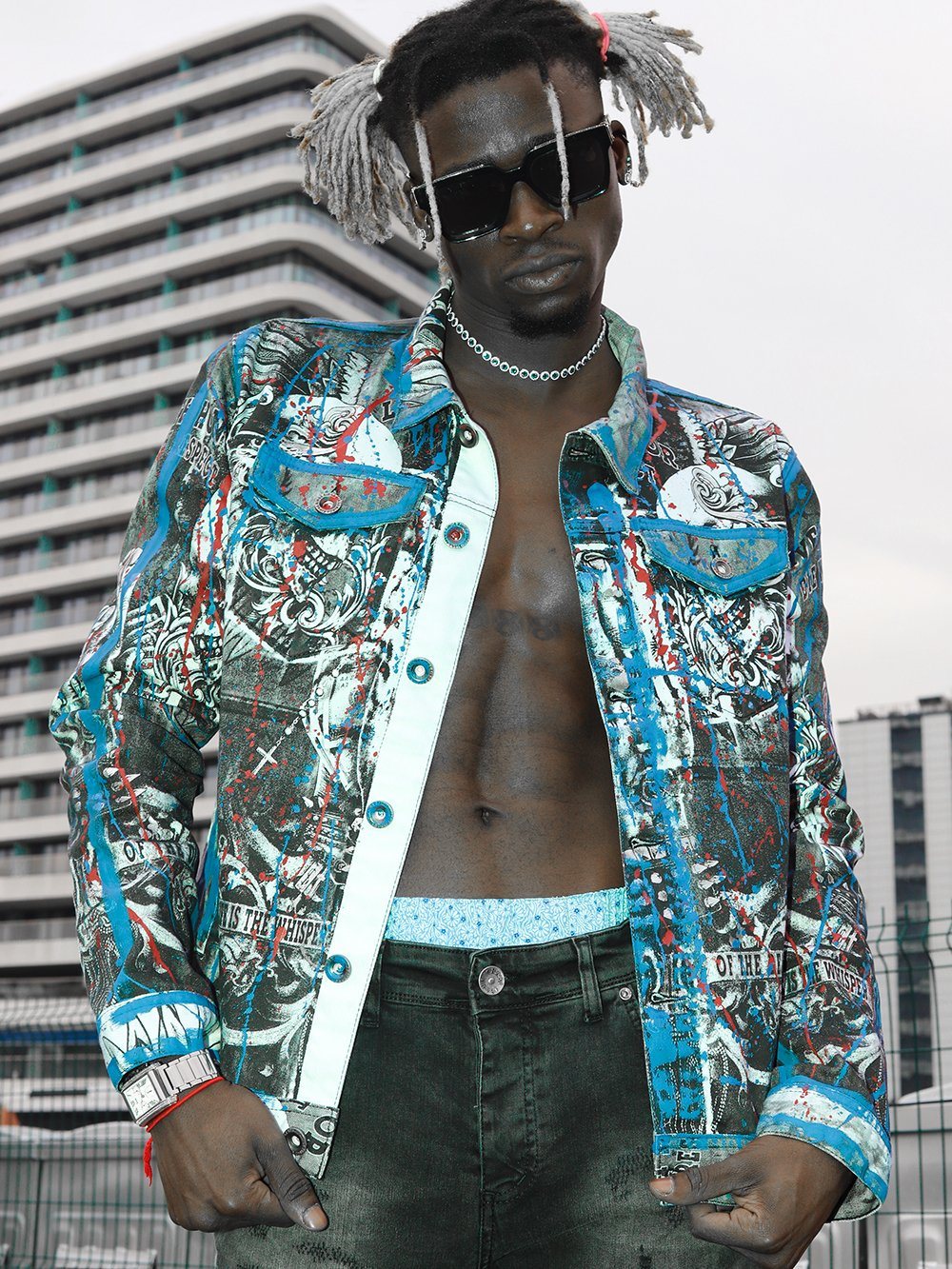 A man wearing a denim jacket and skinny fit jeans with LA VIDA LOCA.