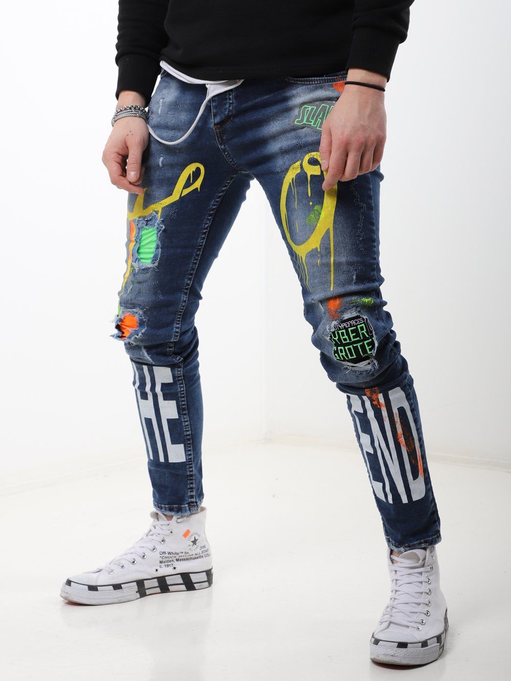 A man wearing a pair of MY WAY jeans with graffiti on them.
