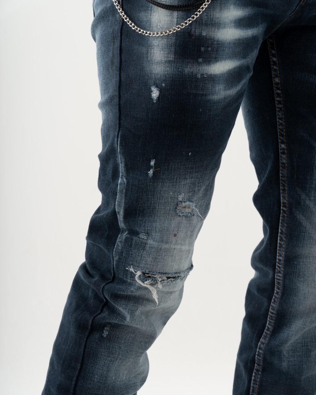 A man sporting LIGHTNING jeans with chains, creating a fashionable look for mens streetwear.