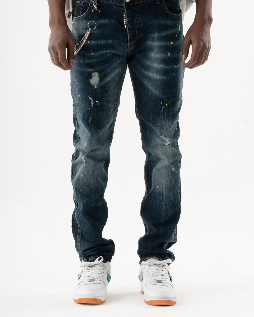 A man wearing a pair of KUDOS jeans and sneakers.