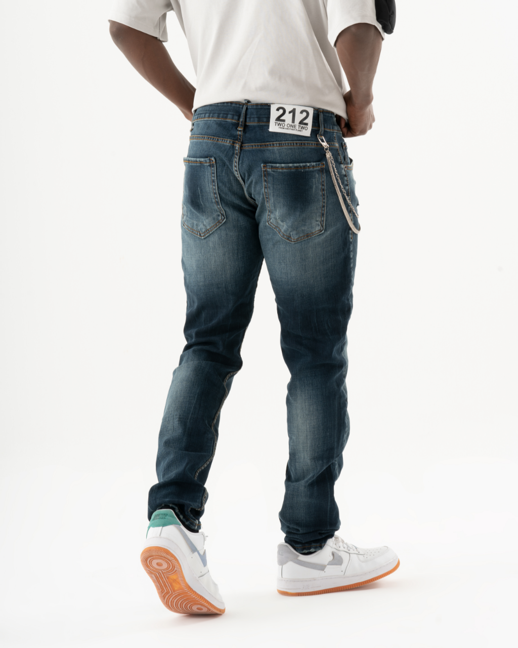 A man wearing a pair of KUDOS jeans and a white t-shirt.