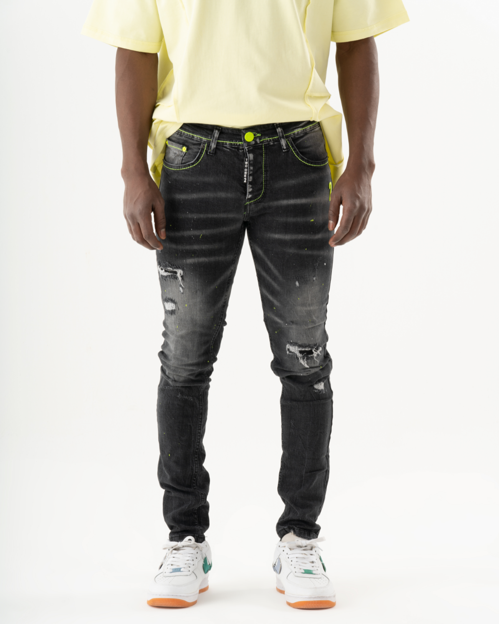 A man wearing INKLING skinny fit black jeans and a yellow t - shirt.