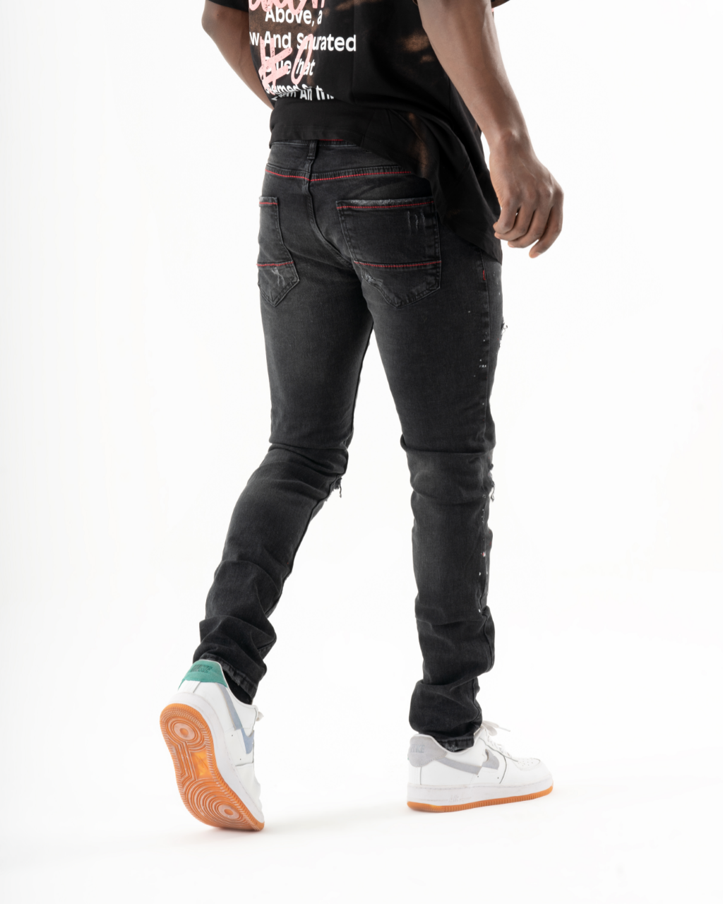 A man donning black HOTSPOT jeans and a white t-shirt exudes mens streetwear style.