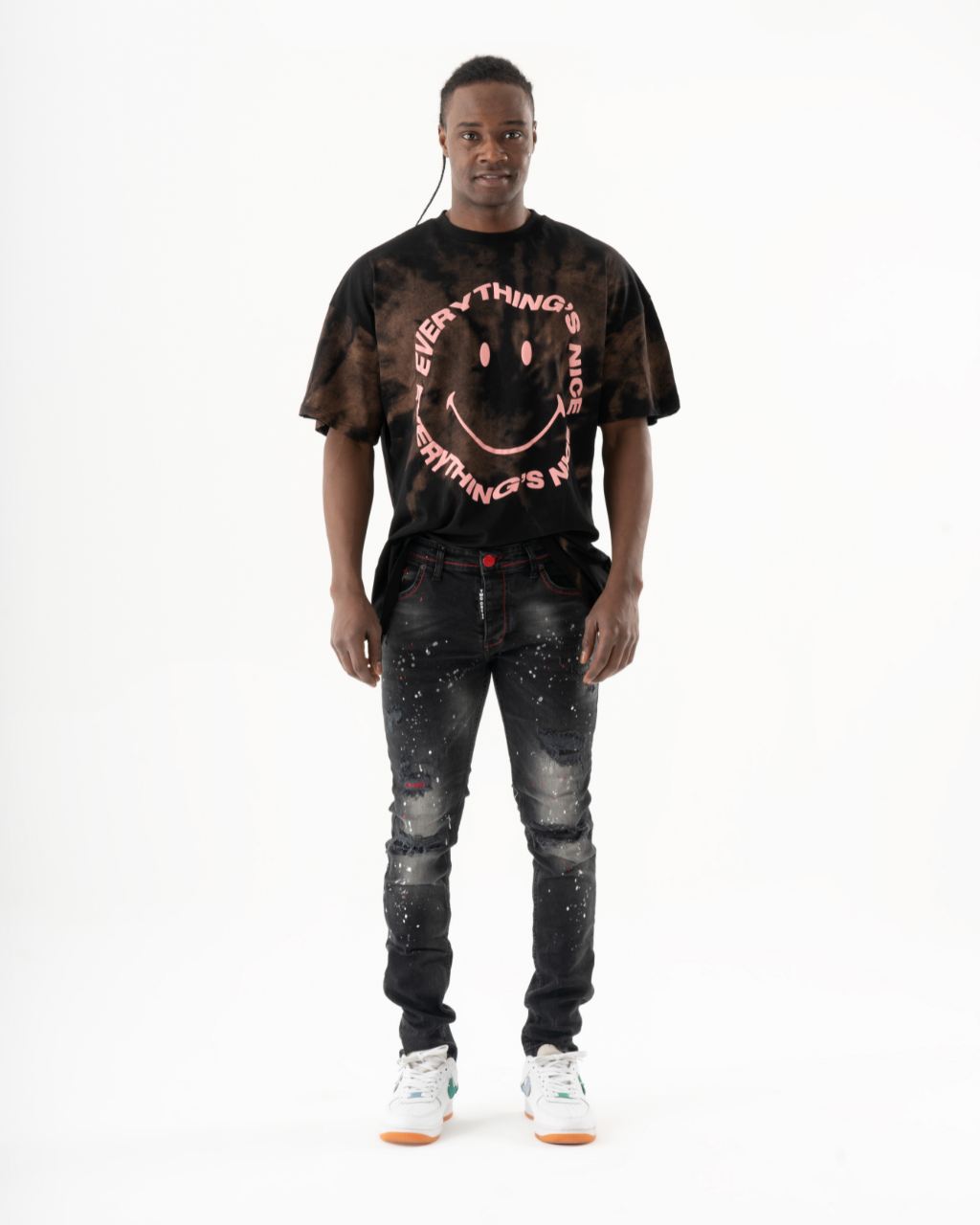 A man wearing ripped jeans and a HOTSPOT t-shirt.