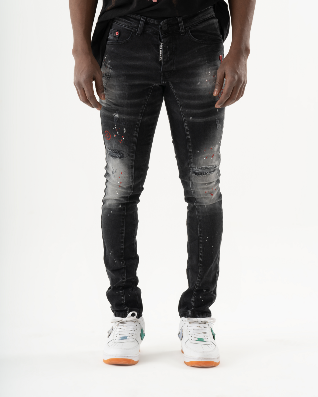 A man wearing ripped THUNDERBIRD jeans and a white t-shirt.