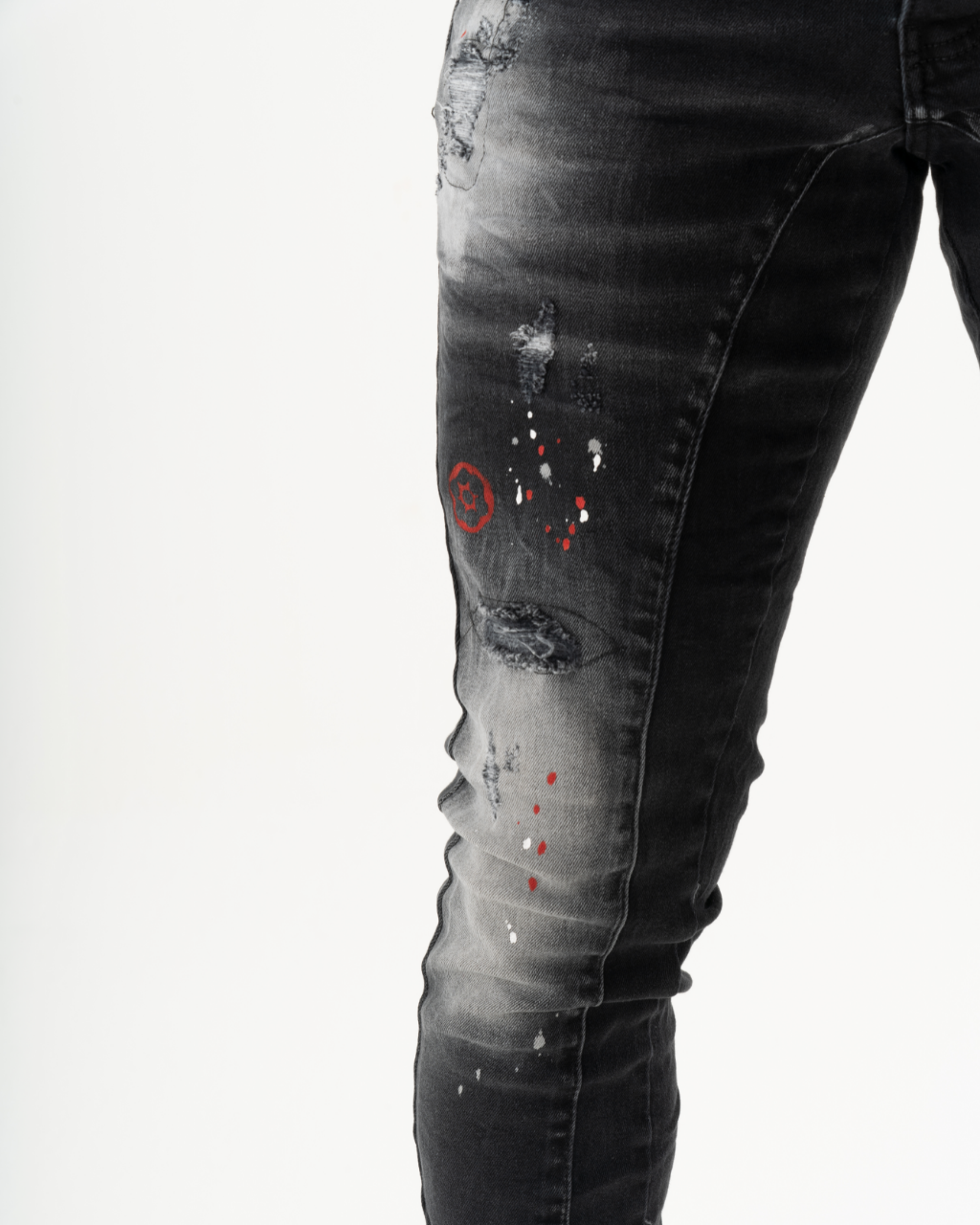 A man is wearing a pair of THUNDERBIRD skinny fit jeans with added stretch, featuring red paint stains.