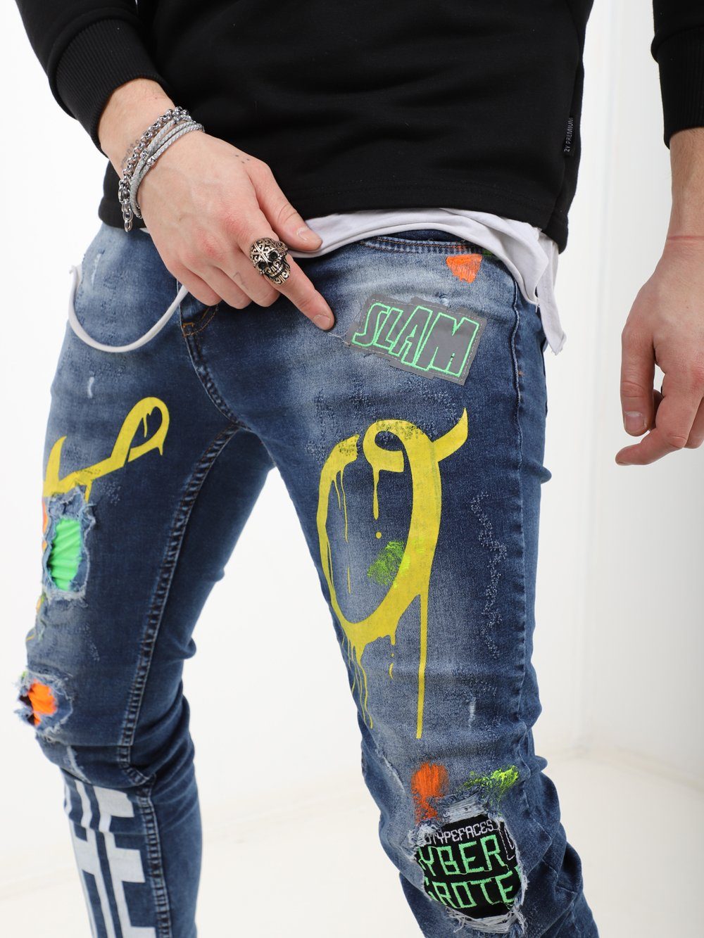 A man wearing a pair of MY WAY jeans with graffiti on them.