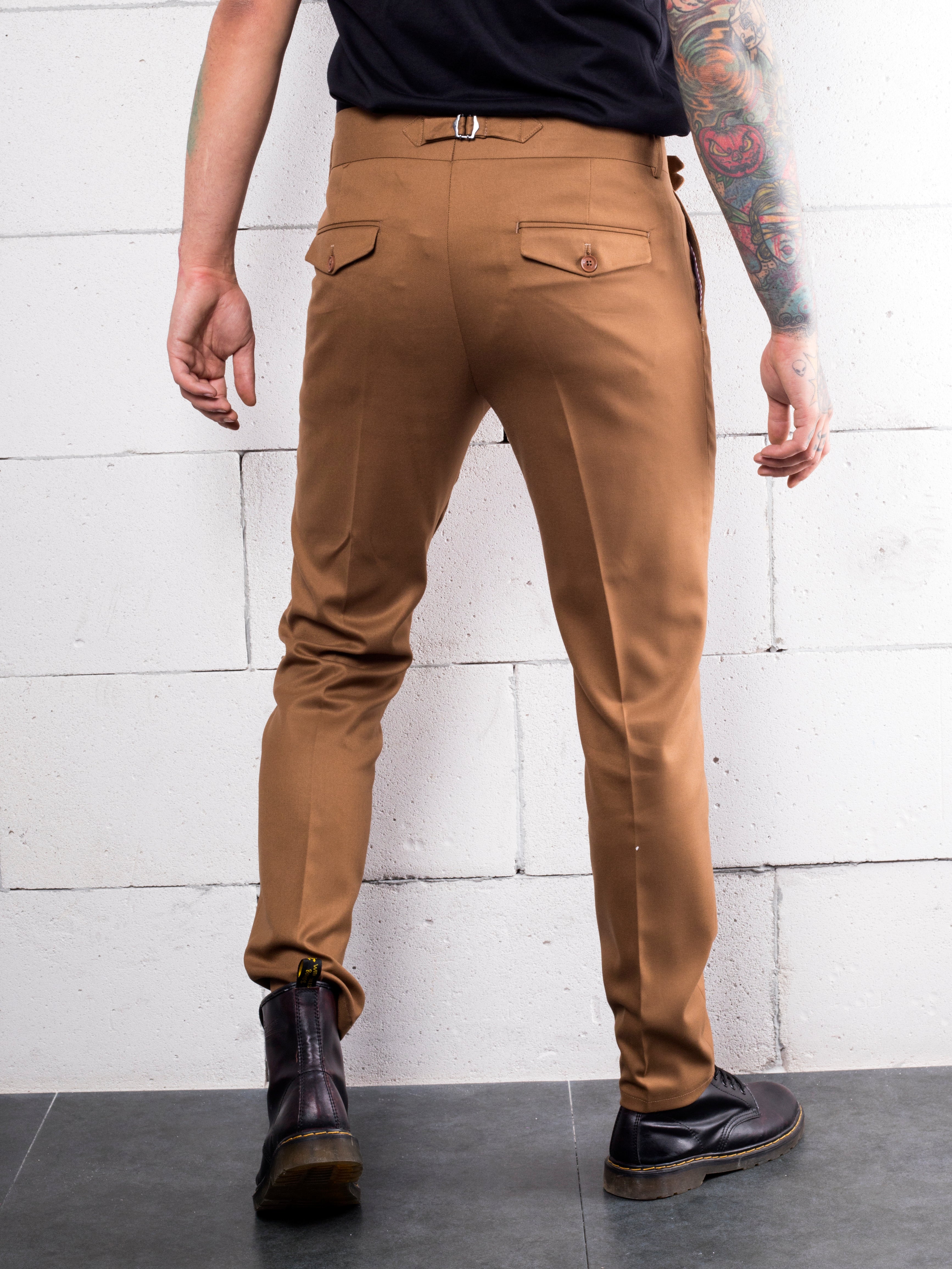 A man with tattoos wearing CROISSANT slacks made from Italian fabric.