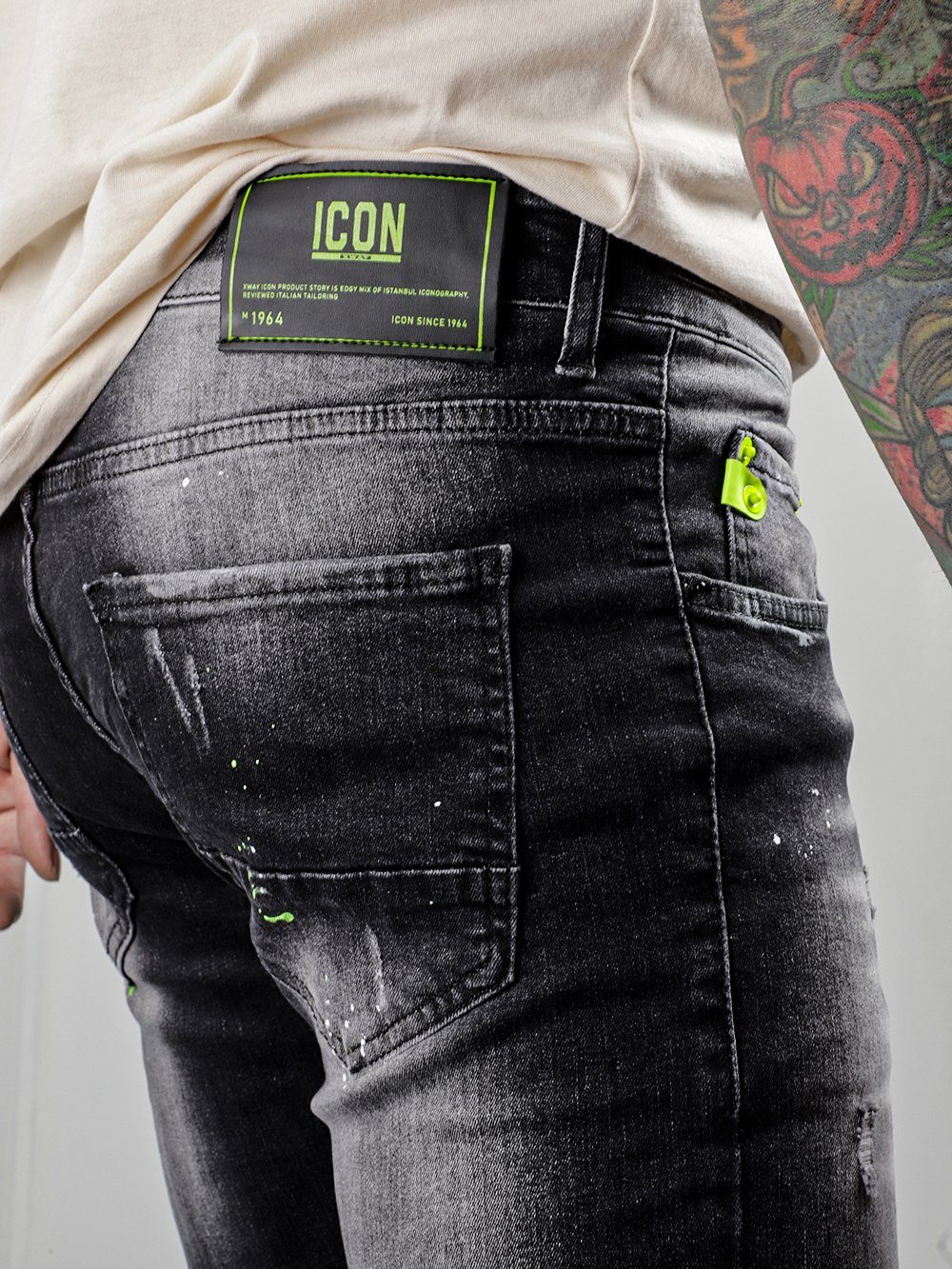 A man wearing a pair of NEON TALK jeans with a tattoo on his back.