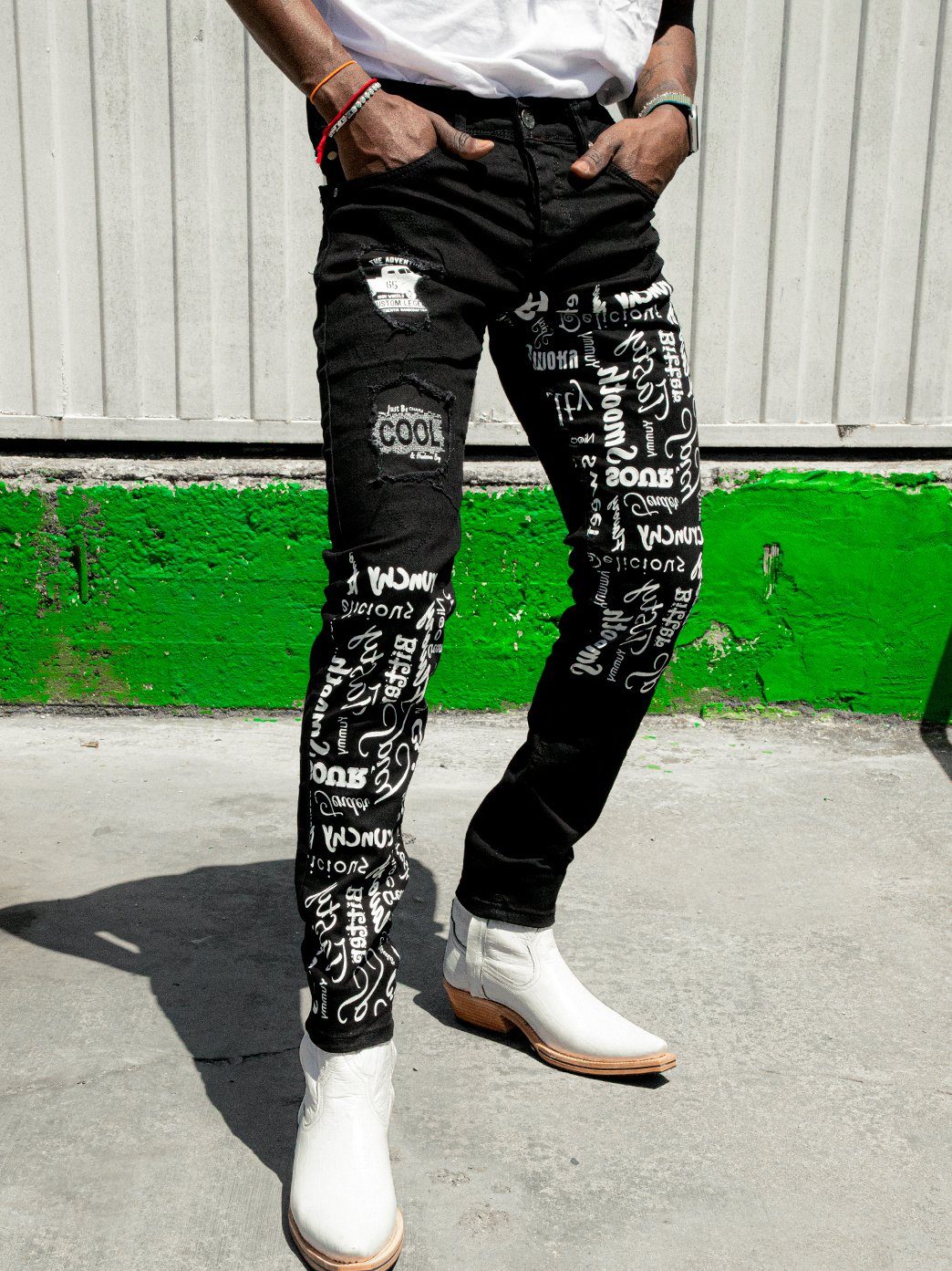 Shot of a man wearing the skinny fit streetwear jeans called THE MECHANIC by SERNES with lots of text printed on it
