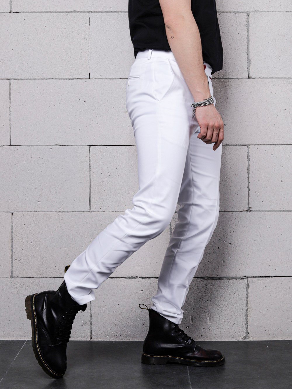 A man wearing CREAM FRAPPUCCINO pants and black boots.