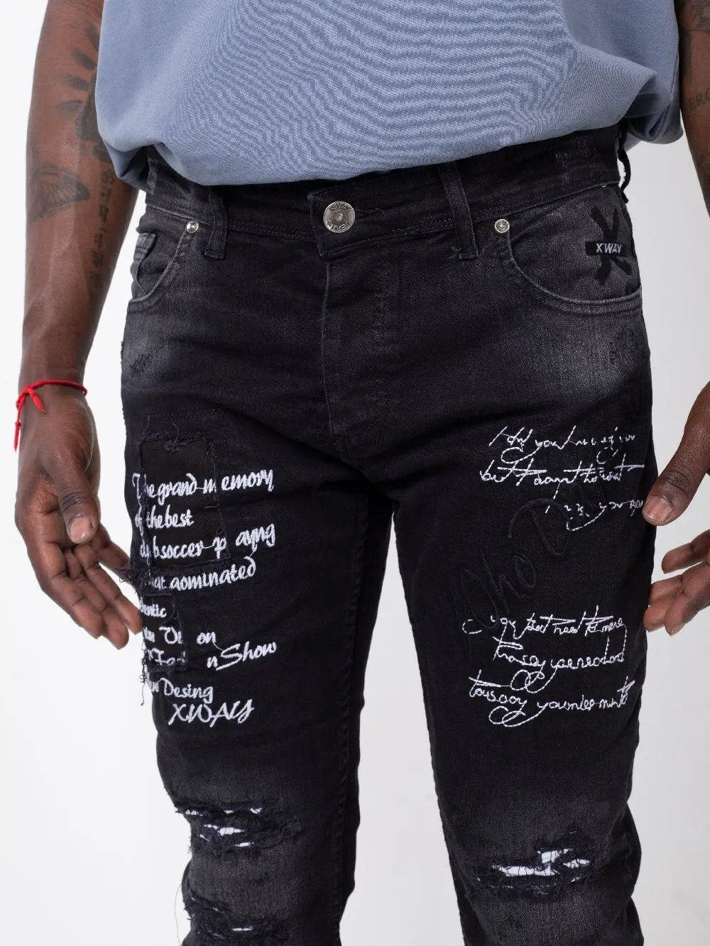 A man wearing Black Stone jeans with writing on them.