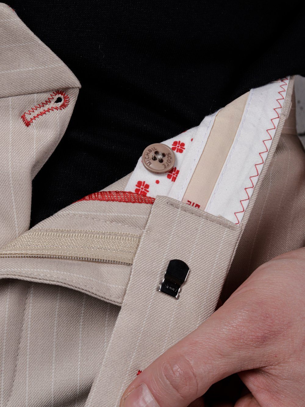 A man's LA CREME skinny fit pants pocket with a red button.
