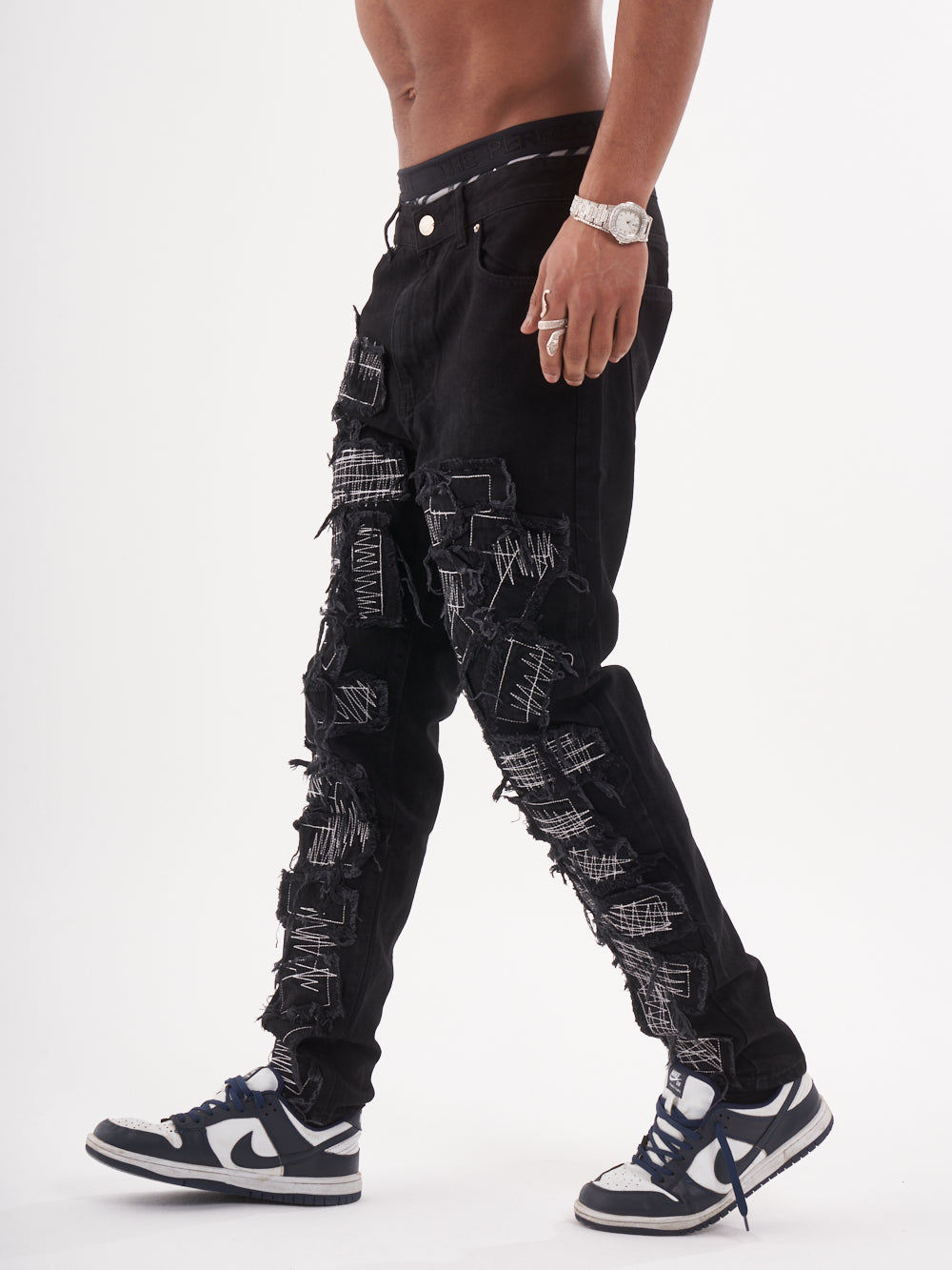 Lower body shot of a man in a black color BLUEPRINT streetwear jeans by SERNES