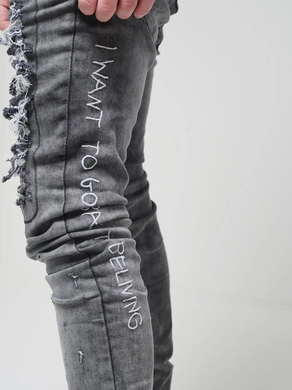 Side close up shot of a man wearing skinny streetwear jeans called THE OUTLAW Jeans by SERNES