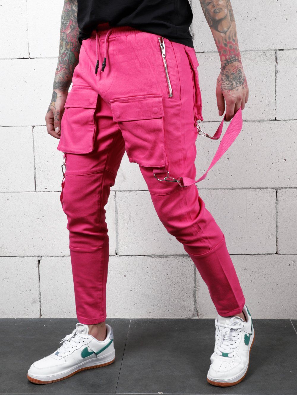 A man wearing PINK BRONX cargo pants with zippers.