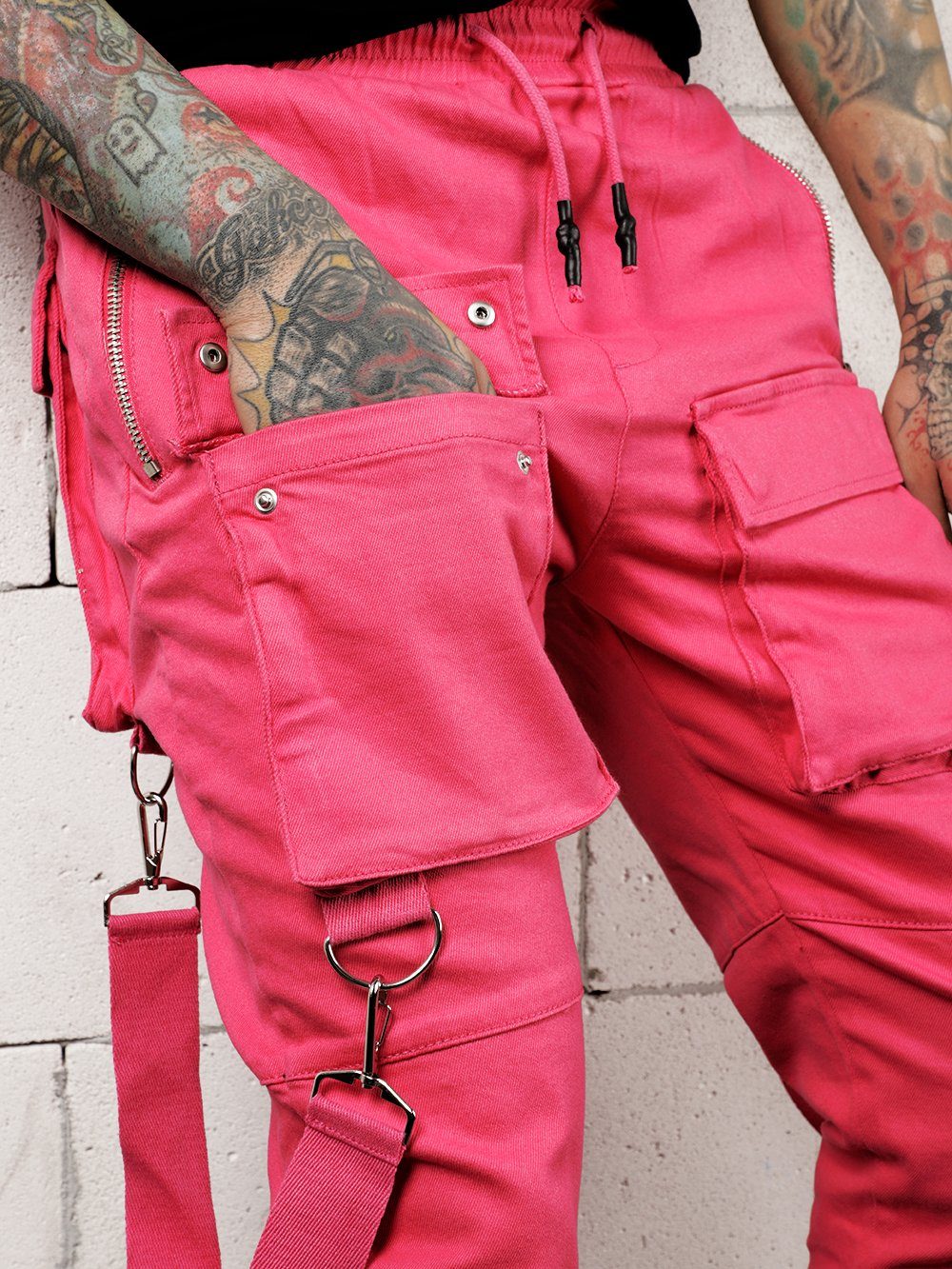 A man with tattoos wearing PINK BRONX cargo pants.